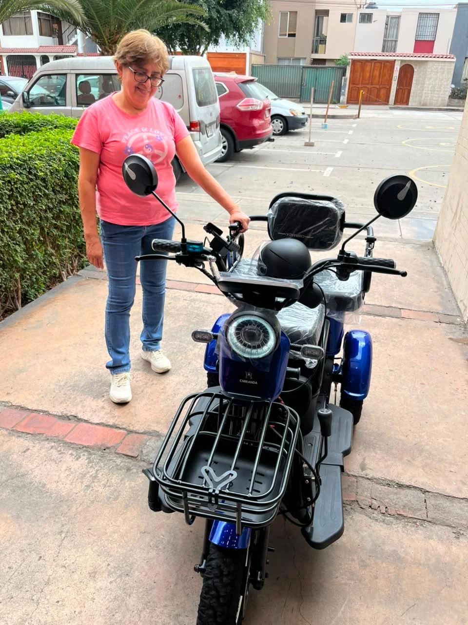 Clienta Dorcas con trimoto electrica azul